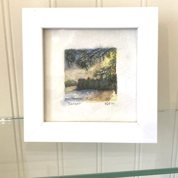 A sunset watercolor painting in a white frame